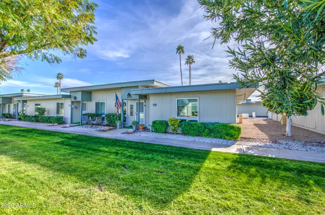a front view of a house with a yard and potted plants