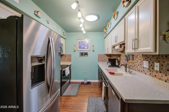a kitchen with stainless steel appliances a refrigerator sink and stove