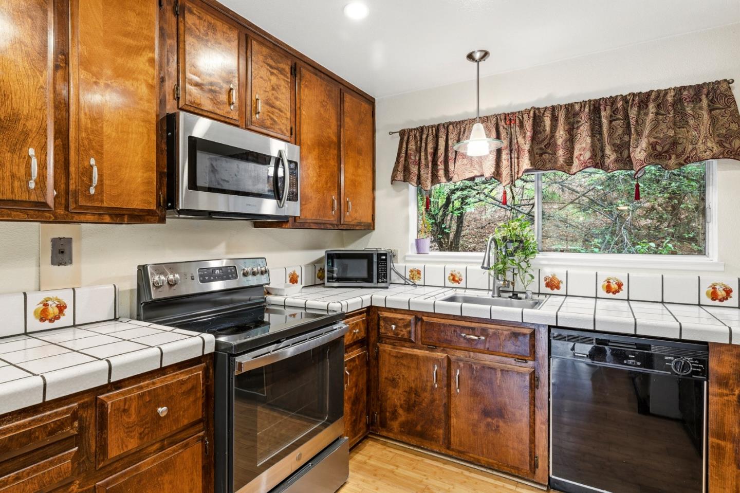 1743 Panda Way Hayward, CA 94541 - Photo 17 of 34 a kitchen with stainless steel appliances a stove sink microwave and cabinets