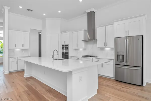 a kitchen with stainless steel appliances a refrigerator and a stove top oven