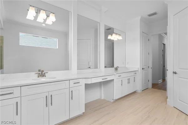a bathroom with a sink vanity granite tub and a mirror