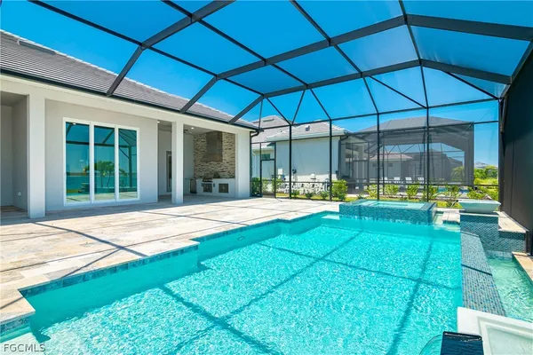 a backyard of a house with table and chairs under an umbrella
