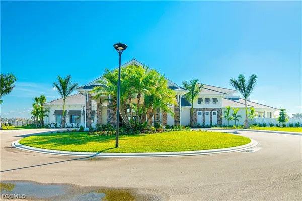 a view of a swimming pool with a yard and palm trees