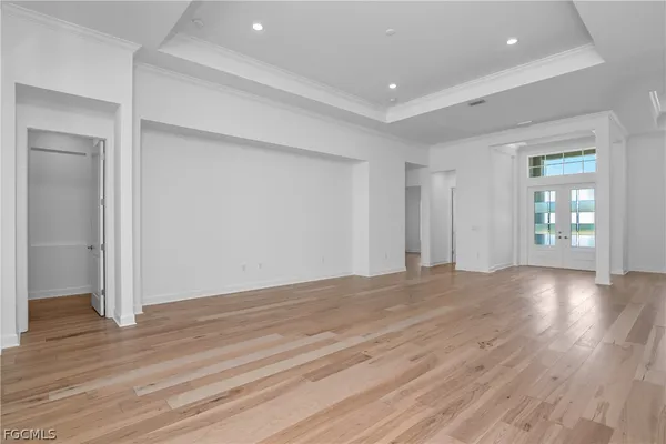 a view of an empty room with wooden floor and windows