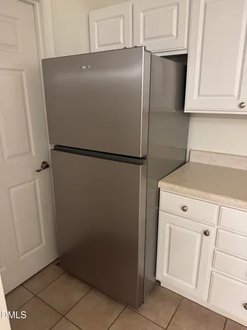 a white refrigerator freezer and a stove sitting inside of a kitchen
