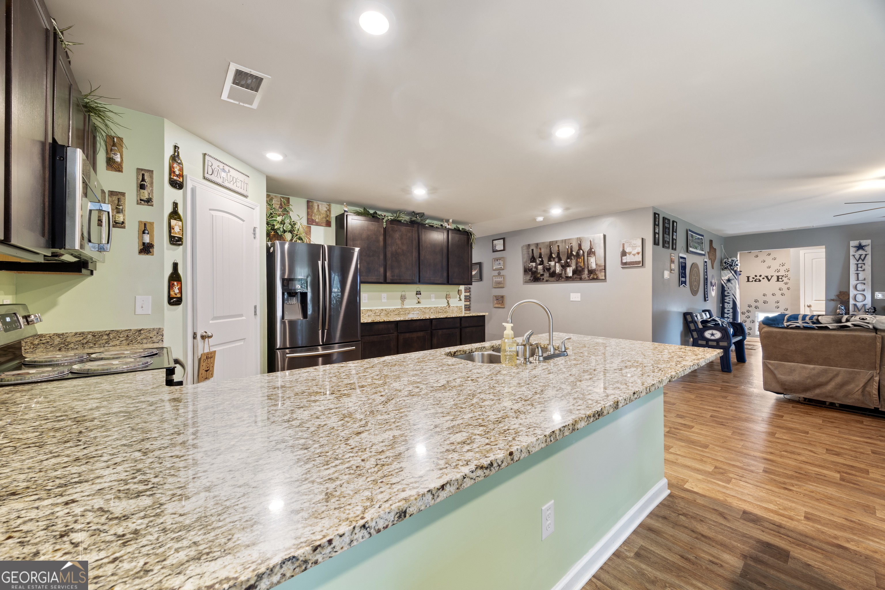 94 Galway Lane Hampton, GA 30228 - Photo 25 of 25 a large kitchen with kitchen island a sink appliances and a counter top space
