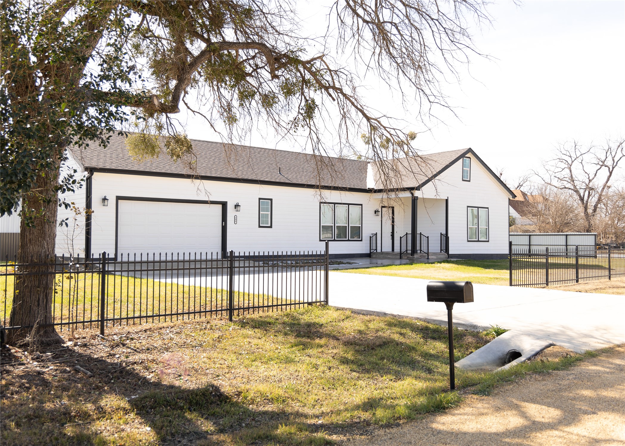 View of front facade featuring concrete driveway and an attached garage