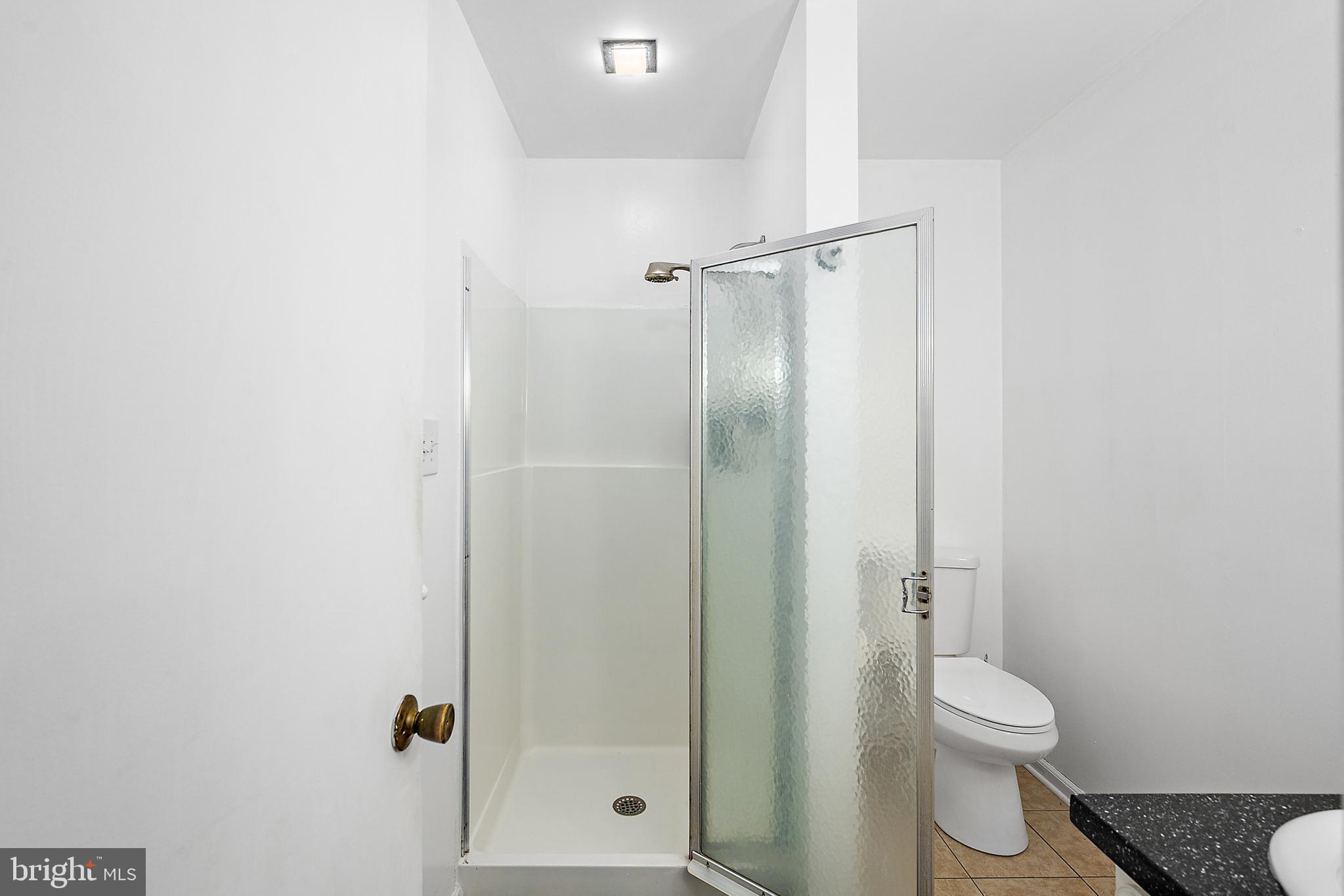 6181 Rockawalkin Road Salisbury, MD 21801 - Photo 50 of 65 a bathroom with a granite countertop toilet a sink and shower