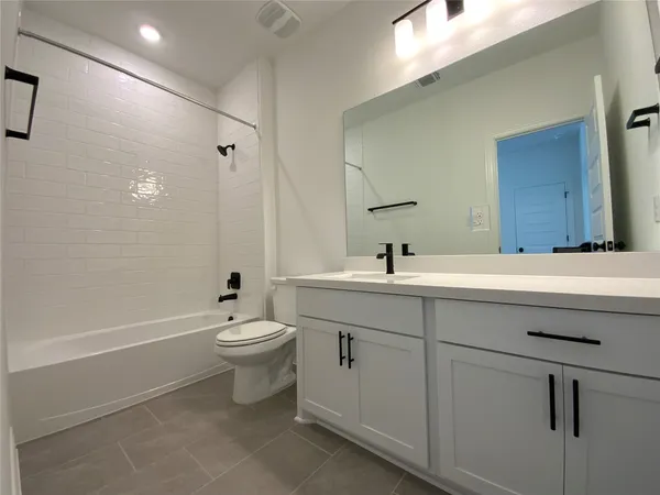 a bathroom with a double vanity sink toilet mirror and bathtub