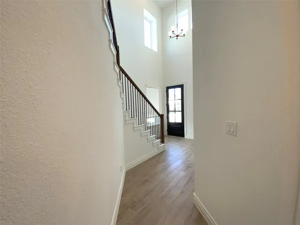 a view of a hallway with wooden floor and entryway