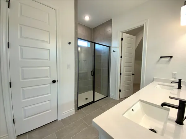 a bathroom with a double vanity sink mirror double and shower