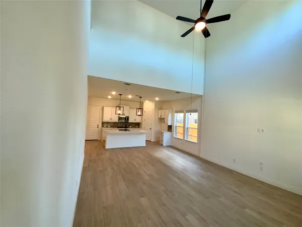 a view of a room with a kitchen and wooden floor