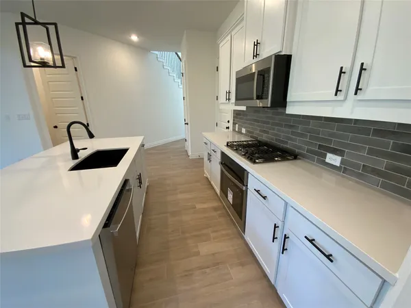 a kitchen with granite countertop a sink and a stove top oven
