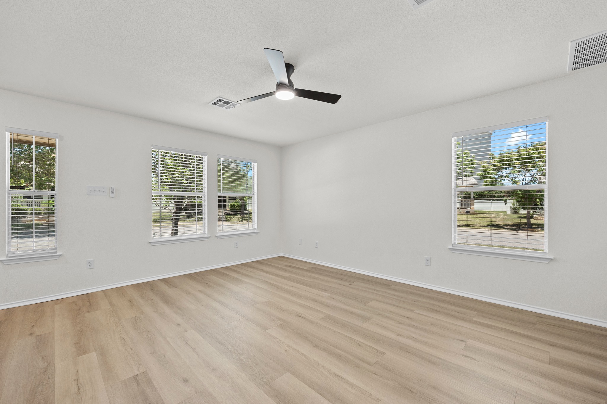 1818 Lost Maples Loop Cedar Park, TX 78613 - Photo 7 of 38 A well-lit room showcases durable laminate flooring, ideal for a flexible living space.