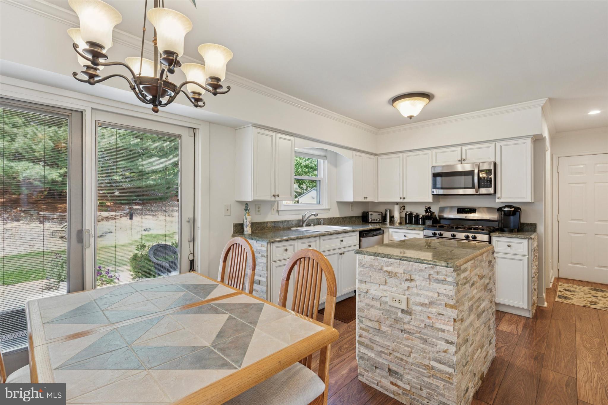 1402 Valley View Warrington, PA 18976 - Photo 14 of 51 a kitchen with stainless steel appliances granite countertop a stove top oven a sink dishwasher a dining table and chairs with wooden floor