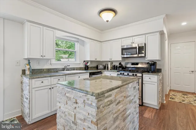 a kitchen with appliances a sink and cabinets
