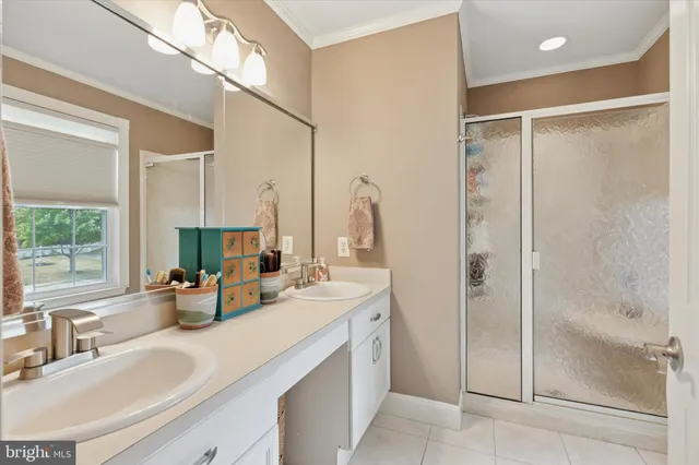 a bathroom with a double vanity sink mirror and shower