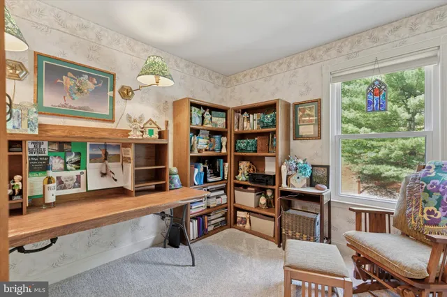 a view of a livingroom with workspace and a window