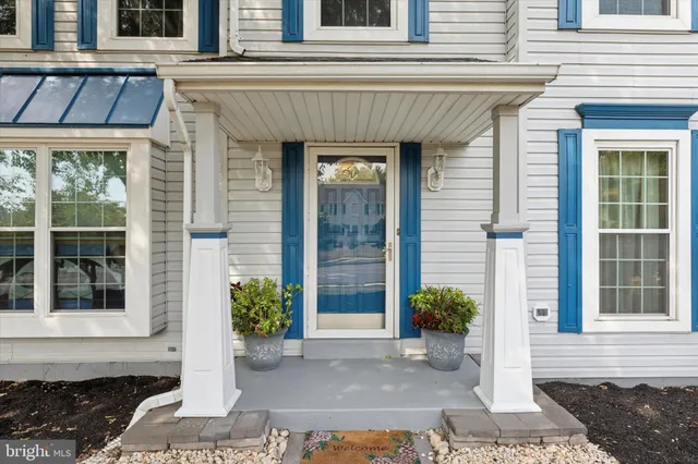 a front view of a house with potted plants