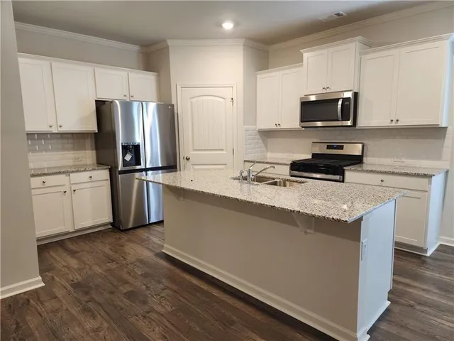 a view of kitchen with wooden floor and electronic appliances