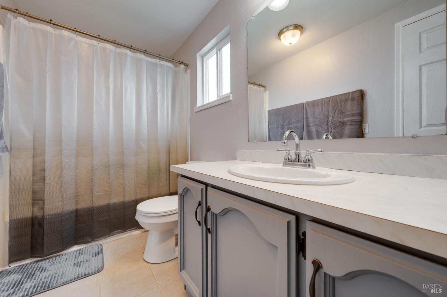 7500 North Meridian Road Vacaville, CA 95688 - Photo 28 of 38 a bathroom with a sink a toilet and shower curtain