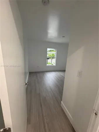 an empty room with windows and wooden floor