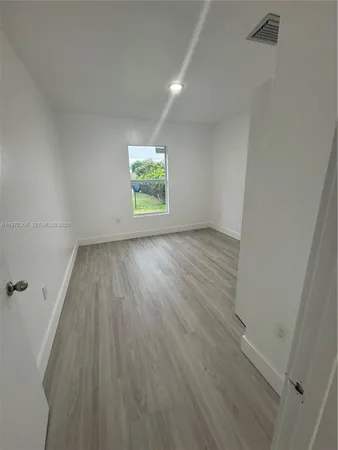 an empty room with windows and closet