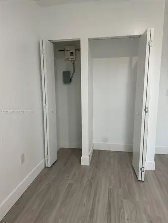 an empty room with wooden floor and closet