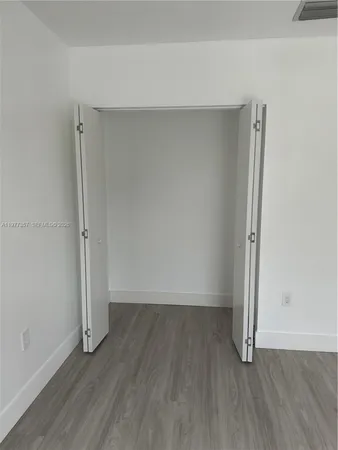 an empty room with wooden floor and a window