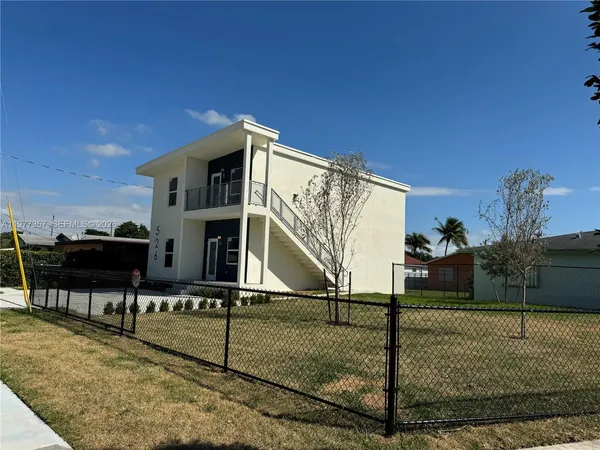 a view of a house with a wooden fence