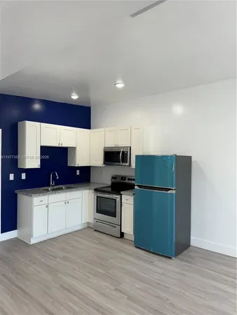 a kitchen with stainless steel appliances a refrigerator and a stove top oven