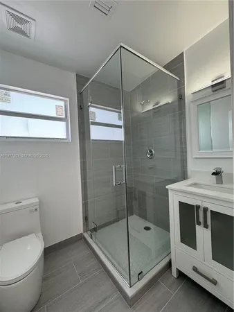 a bathroom with a shower a mirror and a sink