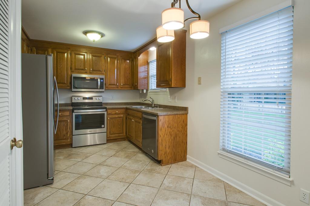 1243 General George Patton Road Nashville, TN 37221 - Photo 4 of 25 a kitchen with stainless steel appliances granite countertop a stove a sink and a refrigerator