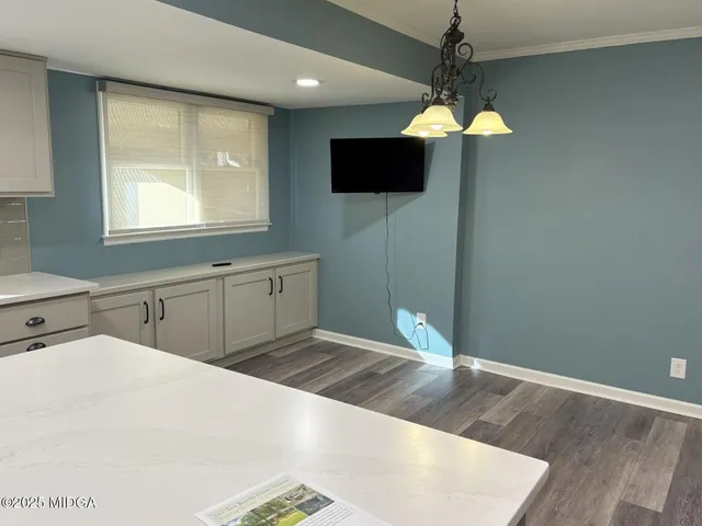 a kitchen with a refrigerator and a flat screen tv