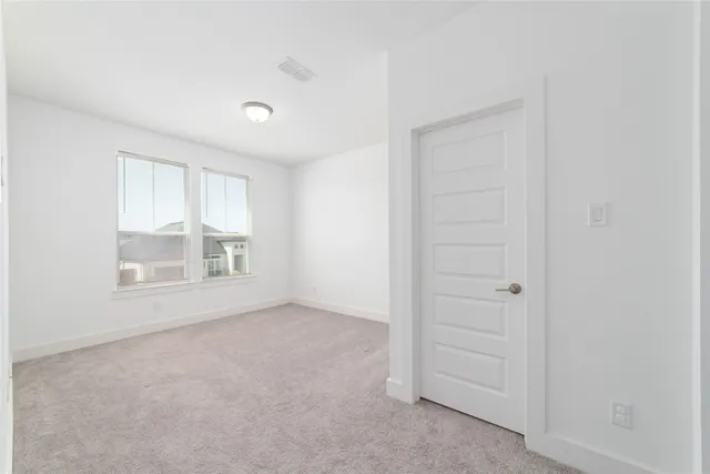 an empty room with windows and closet