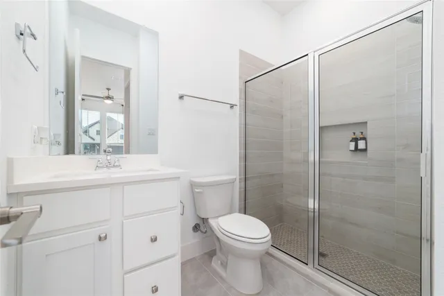 a bathroom with a shower sink vanity mirror and toilet