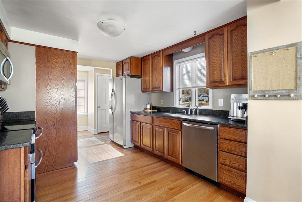 10 Audrea Road Framingham, MA 01701 - Photo 6 of 22 a kitchen with stainless steel appliances granite countertop a refrigerator a sink dishwasher a stove top oven a refrigerator and island with wooden floor