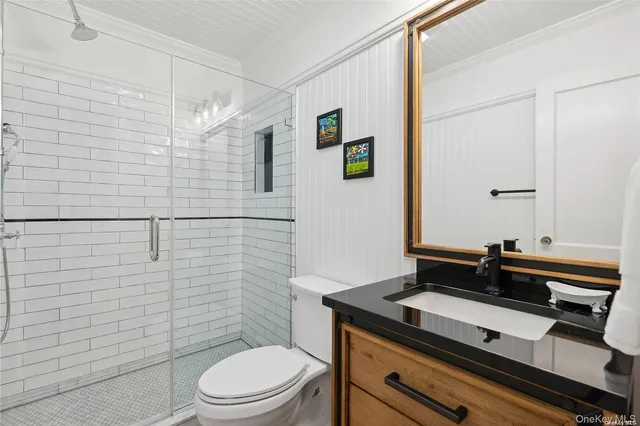 a bathroom with a sink a toilet and shower