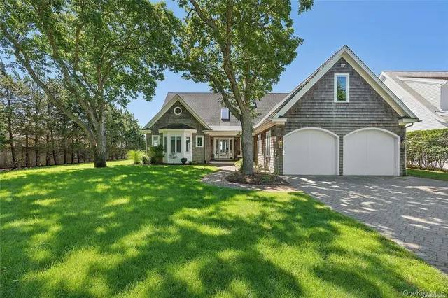 a front view of a house with yard and green space