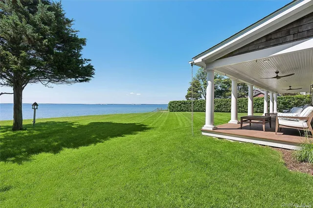 a view of backyard with a table and chairs under an umbrella