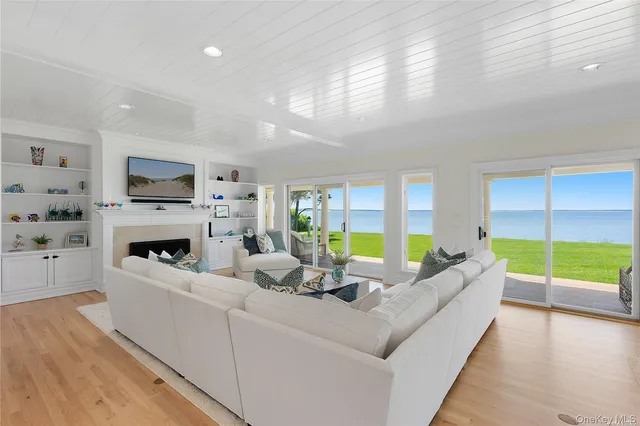 a living room with furniture fireplace and a large window
