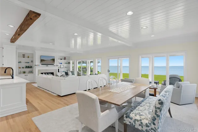 a living room with furniture kitchen view and large windows