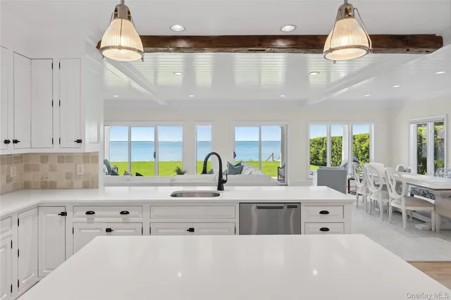 a kitchen with stainless steel appliances a white cabinets and a chandelier