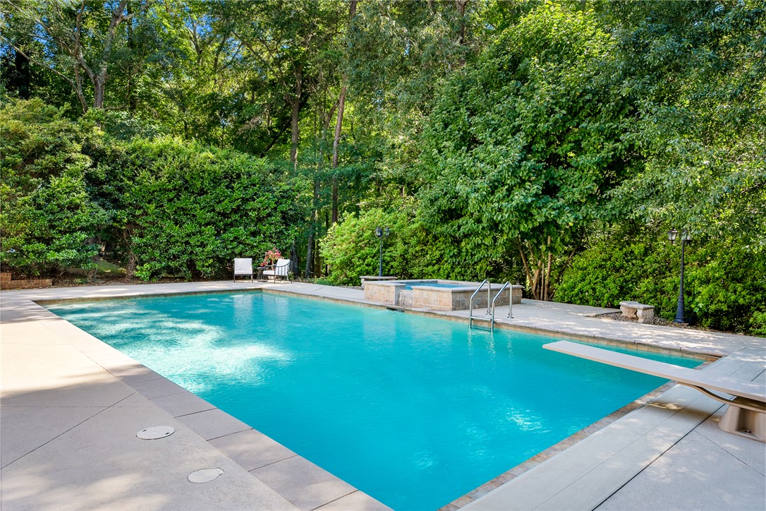 200 Graylyn Drive Anderson, SC 29621 - Photo 40 of 48 An inviting backyard oasis offers a sparkling pool with a diving board and an adjacent spa.