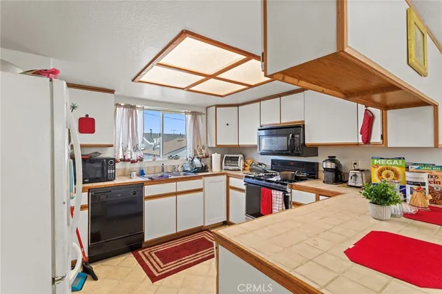 a kitchen with stainless steel appliances granite countertop a sink dishwasher stove top oven and cabinets