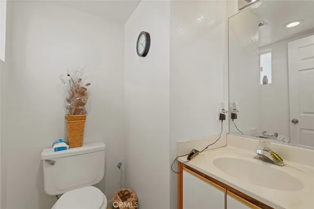 a bathroom with a sink vanity mirror and toilet