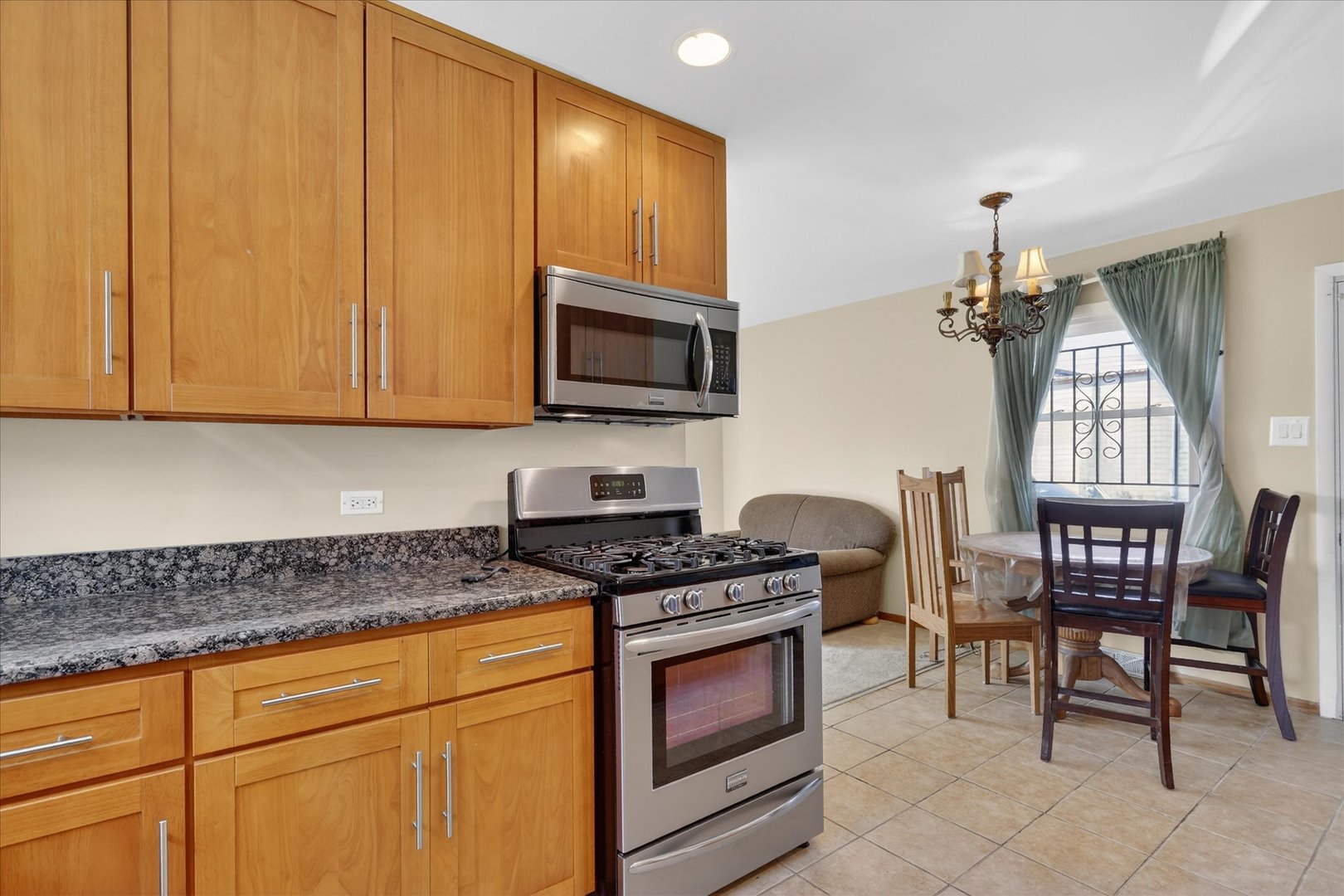 14911 Page Avenue Harvey, IL 60426 - Photo 13 of 35 a kitchen with granite countertop a stove a sink and a microwave