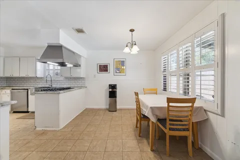 a kitchen with a table chairs sink and cabinets