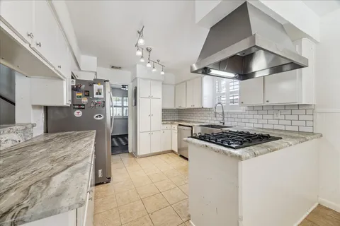 a kitchen with white cabinets and appliances
