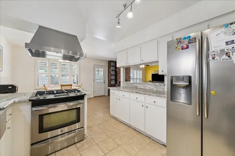 a kitchen with cabinets and chairs